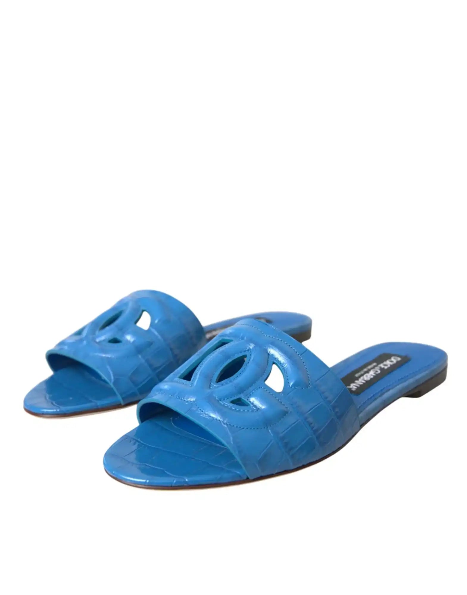 Blue suede slide sandals with decorative cutout pattern.