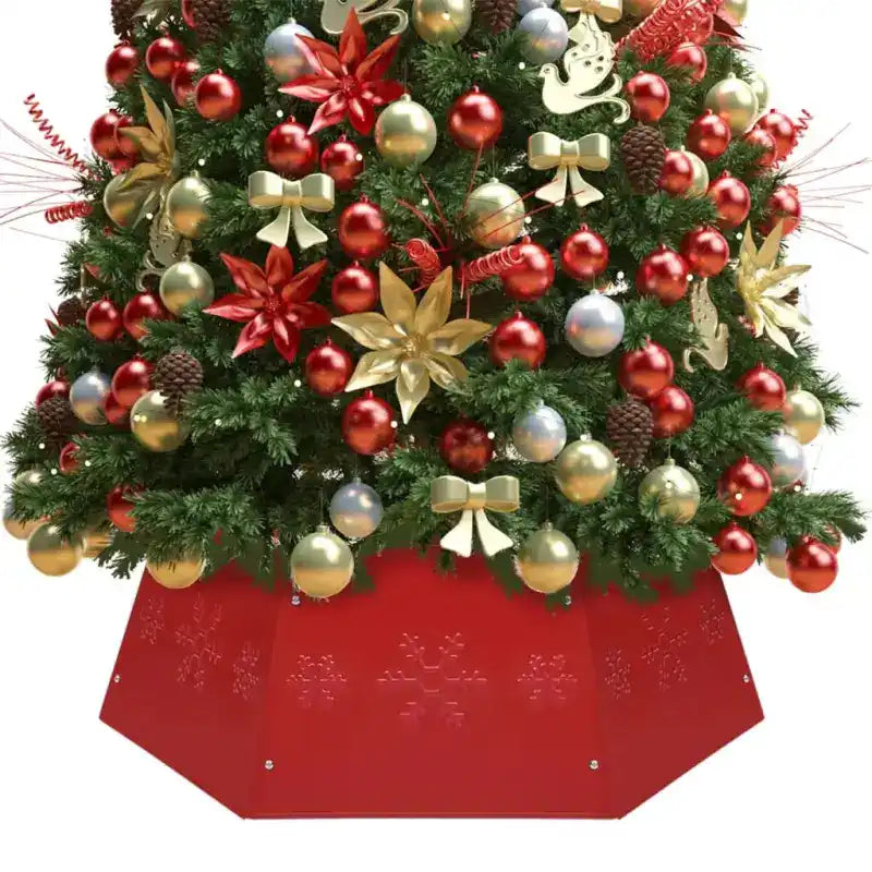 Christmas tree decorated with red and gold ornaments, bows, and poinsettias sitting in a red tree skirt.