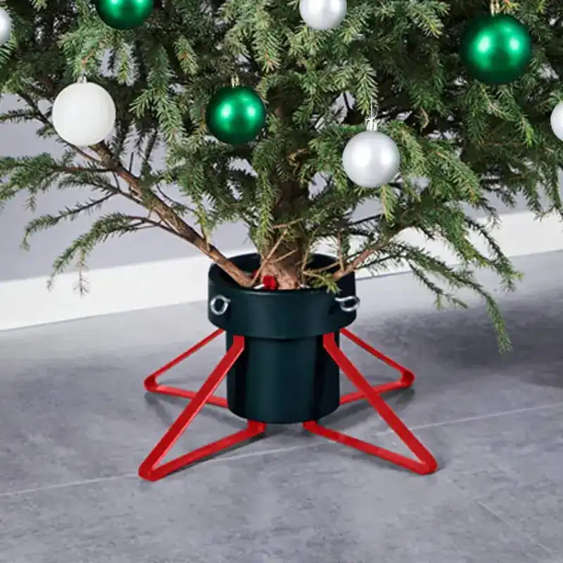 Christmas tree stand with red metal legs and a black base holding evergreen branches decorated with green and white ornaments.