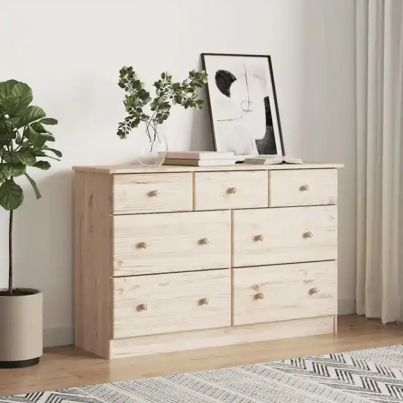 Light-colored wooden dresser with seven drawers and silver knobs.